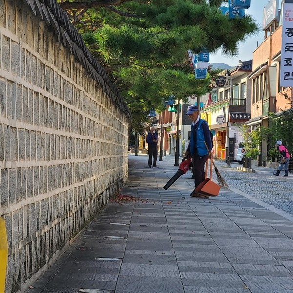 슝~하는 송풍기를 이용해 주말 아침 경기전 서문쪽 담을 청소하는 원국씨