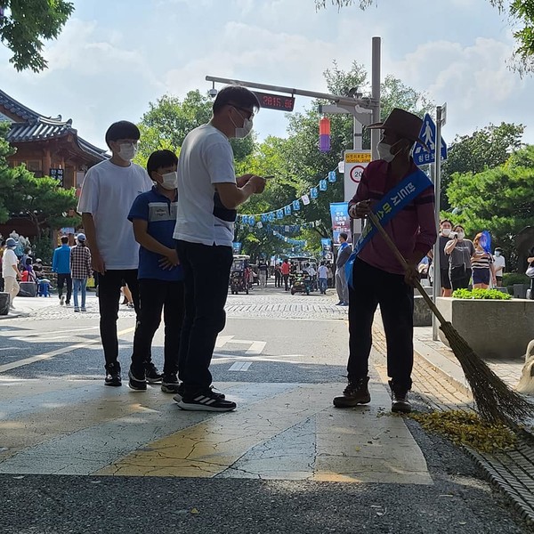 관광객들과 대화하며 청소하는 모습