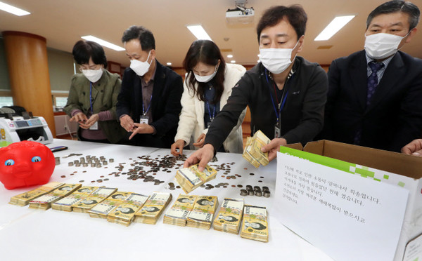 전주시 노송동주민센터 직원들이 29일 ‘얼굴 없는 천사’가 놓고 간 성금을 세고 있다.(사진=전주시 제공)