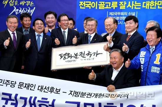 2017년 4월 27일 문재인 더불어민주당 대선후보가 서울 영등포구 여의도 더불어민주당 당사에서 진행된 '내 삶을 바꾸는 정권교체' 정책시리즈 21-'전국이 골고루 잘 사는 대한민국' 자치분권정책 발표 및 지방분권 개헌 국민협약식 후 기념촬영을 하고 있다.(출처: '국민일보', 2017년 4월 28일 자)