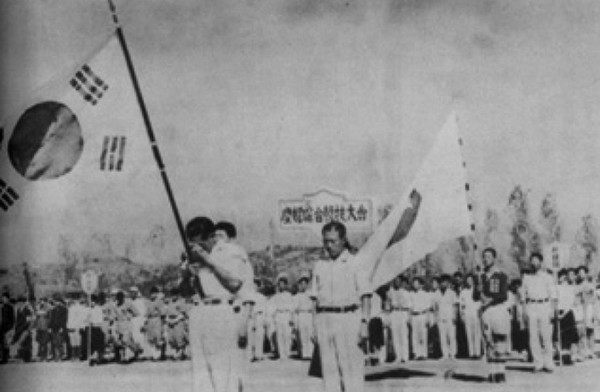 자유해방경축 전국종합경기대회(제26회 전국체육대회) 개회식 장면. 태극기를 들고 입장한 손기정 선수가 감격에 겨워 눈물을 훔치고 있다(출처=군산 야구  100년사)