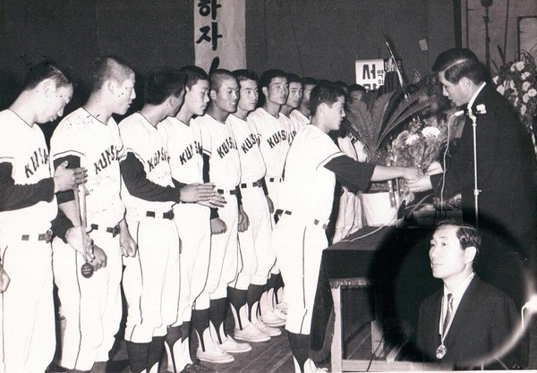 제52회 전국체전에서 우승한 군산상고 선수들이 군산 제일극장에서 열린 환영식에서 이용일 경성고무 사장에게 꽃다발을 전달하고 있다.(출처: 군산 야구 100년사)