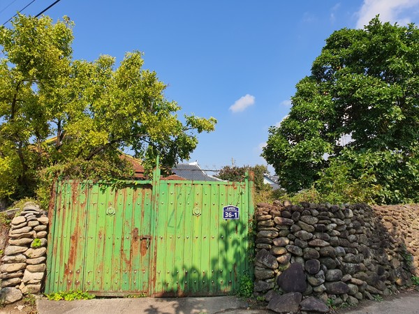                대문이 녹슨 채 굳게 잠긴 농촌 마을 빈집.