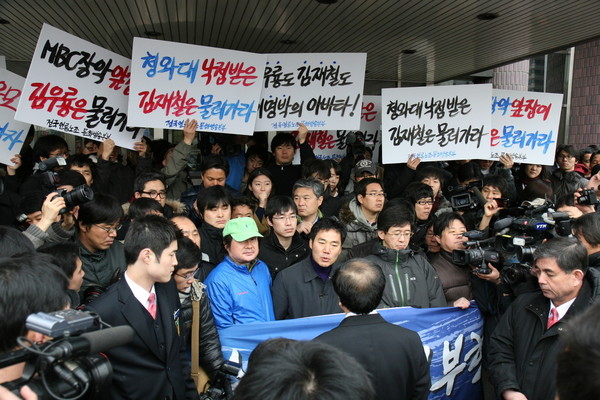 김재철 문화방송 새 사장(뒷 모습)이 2010년 3월 2일 오전 서울 여의도 문화방송 본관 들머리에서 이근행 문화방송 노조위원장(앞 줄 맨 가운데)과 입씨름을 벌이고 있다. (사진 출처: MBC노동조합) 