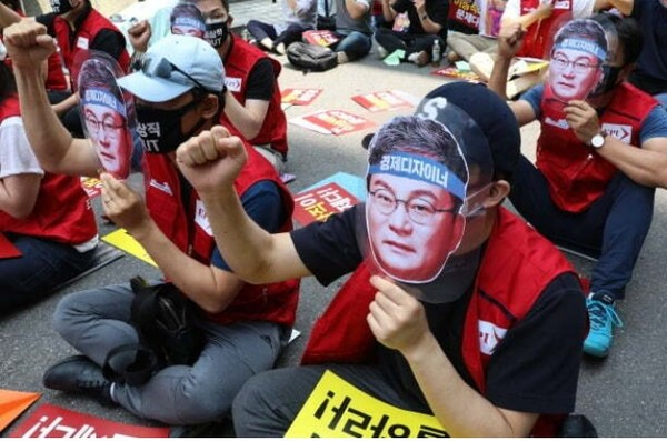 2020년 6월 5일 더불어민주당사 앞에서 열린 이스타항공노동자 결의대회에서 참석자들이 21대 국회의원에 당선된 이상직 의원의 사진을 들고 항공운항 재개와 체불임금 지급을 촉구하고 있다.