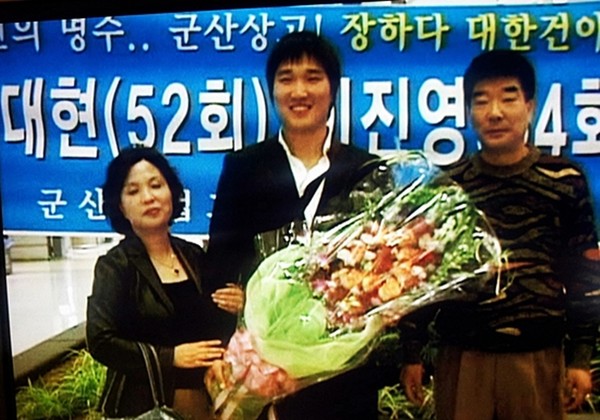 선배들이 내건 환영 현수막 앞에서 부모와 기념촬영하는 이진영 선수
