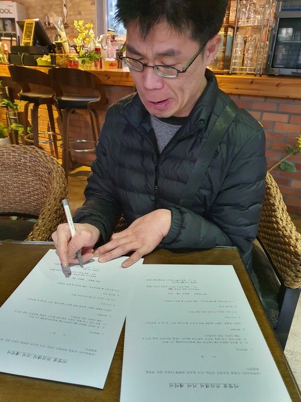 계약서를 꼼꼼히 작성하고 있는 이영광 기자
