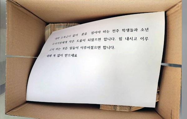 12월 27일 얼굴 없는 천사가 놓고 간 상자 안에는 돈다발과 돼지저금통, 그리고 얼굴 없는 천사가 남긴 쪽지가 함께 있었다.(사진=전주시 제공)