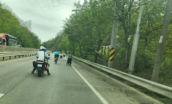 지난 23일 평택의 어느 고갯길에서 필자가 찍은 사진. 휠체어 히프트가 장착된 승합차로 이동을 돕고 대열의 후방을 지키는 그녀가 오르막에서 경찰관에게 자신의 차를 부탁하고 센터장을 밀어주는 모습.