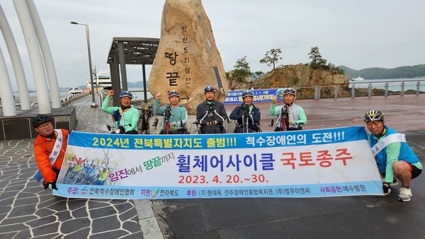 '손으로 국토 종단'팀의 자랑스러운 휠체어사이클 주자 5명이 임진각에서 땅끝항까지 560여km를 종단하고 종착지 표지석에 섰다.