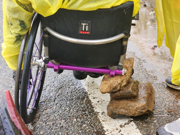 땅끝항을 20여km를 앞두고 펑크 난 타이어 수리를 위해 근처에서 주워온 돌로 휠체어를 지지하고 빗속에서 타이어를 갈아 끼우고 막바지 주행을 해야 했다.