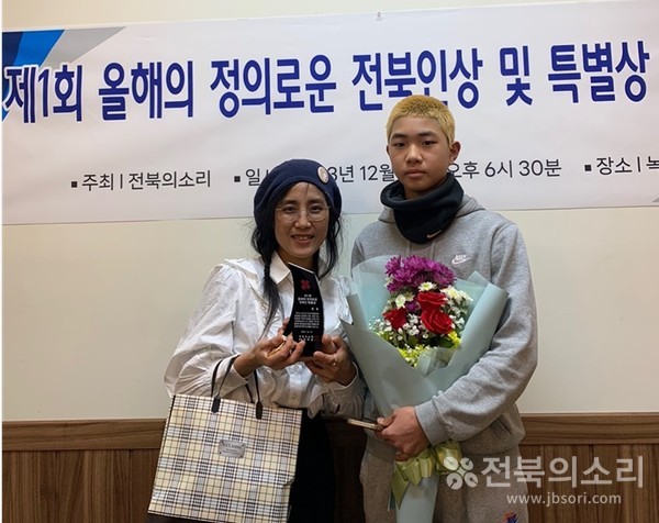 ‘제1회 올해의 정의로운 전북인 특별상’을 수상한 황윤 감독이 수상 후 아들(오른쪽)과 기념사진을 찍고 있는 모습. .