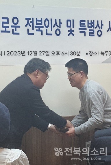 '제1회 올해의 정의로운 전북인상'을 수상한 이영광 씨(오른쪽)에게 상패를 전달한 후 악수를 하고 있는 박주현 전북의소리 대표(왼쪽).
