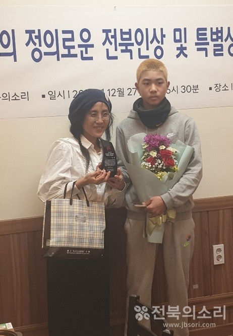 '제1회 올해의 정의로운 전북인 특별상'을 수상한 황윤 감독이 아들(오른쪽)과 함께 수상 소감을 밝히고 있다.