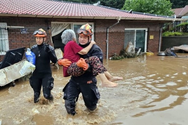 10일 밤사이 완주군 운주면 지역에 폭우가 쏟아져 장선천이 범람하자 119구조대원들이 집 안에 고립된 한 노인을 안아 구조하고 있다.(사진=전북소방본부 제공)