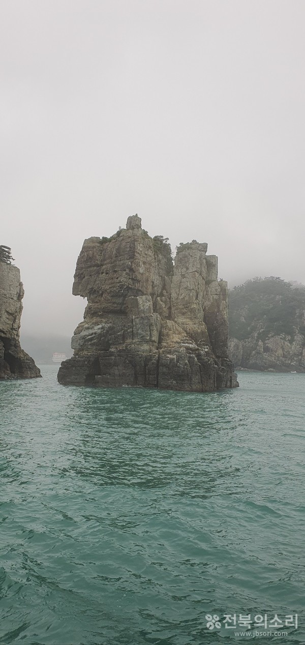 모습이 사자 같기도 하고 사람 같기도 한 바위 사이로 멀리 외도가 보인다.