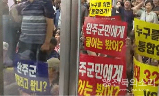 26일 오후 완주군청 회의장 앞을 에워싼 사람들이 '누구를 위한 통합인가', '김관영은 완주군에 오지 마라', '김관영은 우리의 도지사가 아니다' 등의 피켓을 들고 시위를 벌였다.