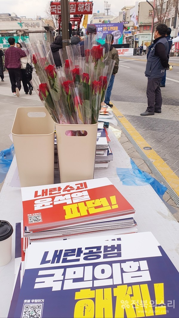 '세계 여성의 날'인 3월 8일 오후 전주 풍패지관(豊沛之館) 앞에서는 '윤석열 파면 1만 도민대회'가 열리기 앞서 주최 측이 시민들에게 장미꽃과 손팻말을 나누어 주고 있다.