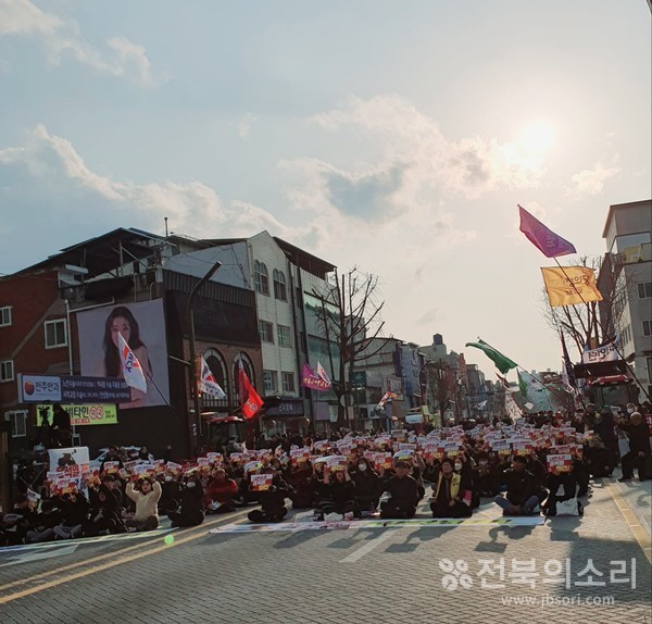 '윤석열 파면 1만 도민대회’에 참가하기 위해 일찌감치 자리를 잡고 앉아서 구호를 외치고 있는 시민들.
