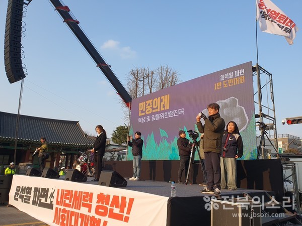 집회 주최 측이 연단에서 발언을 이아가고 있는 모습.